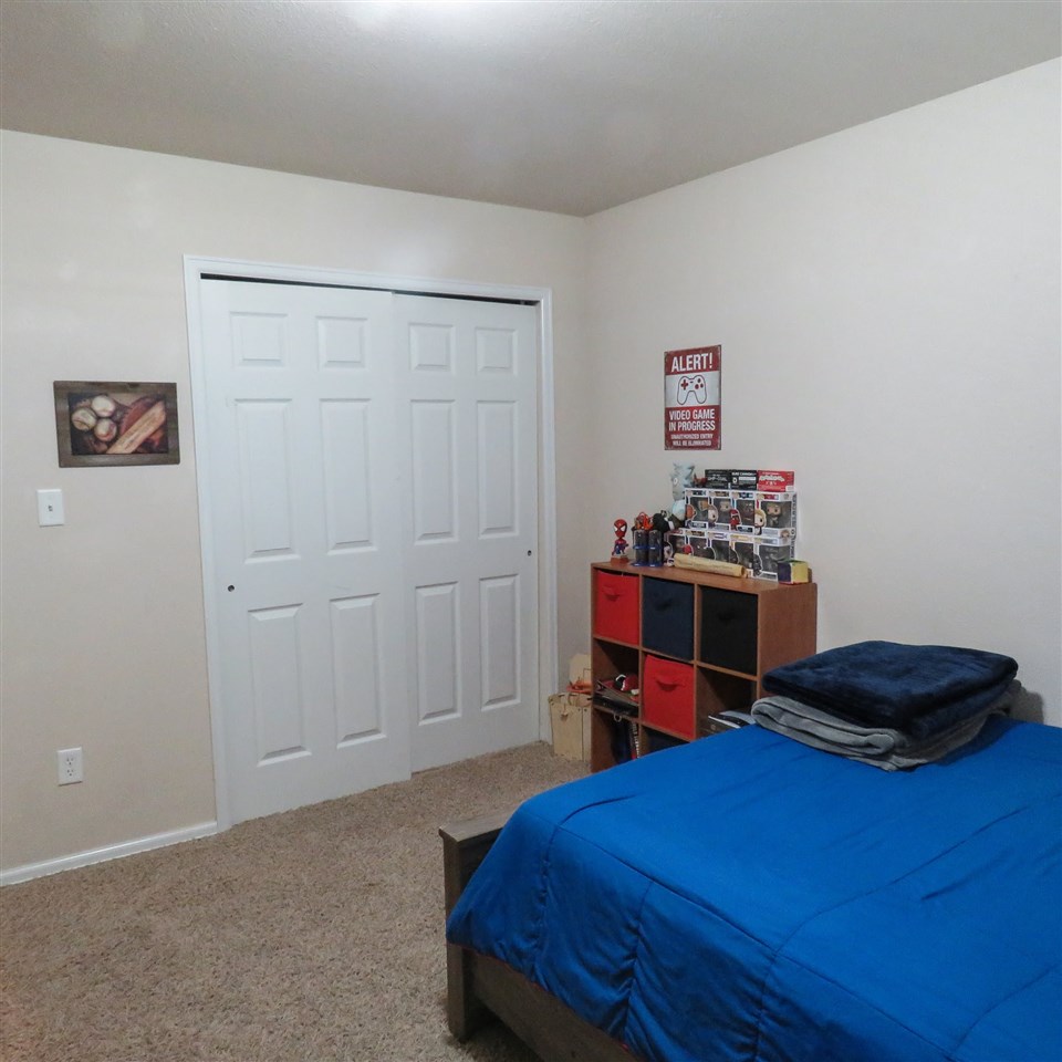 983 Kaley Street Fruita, CO 81521 - Photo 9 of 28 a bedroom with a bed and a dresser in it
