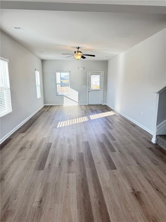 11075 Suria Drive Covington, GA 30014 - Photo 3 of 12 a view of a livingroom with wooden floor and a ceiling fan