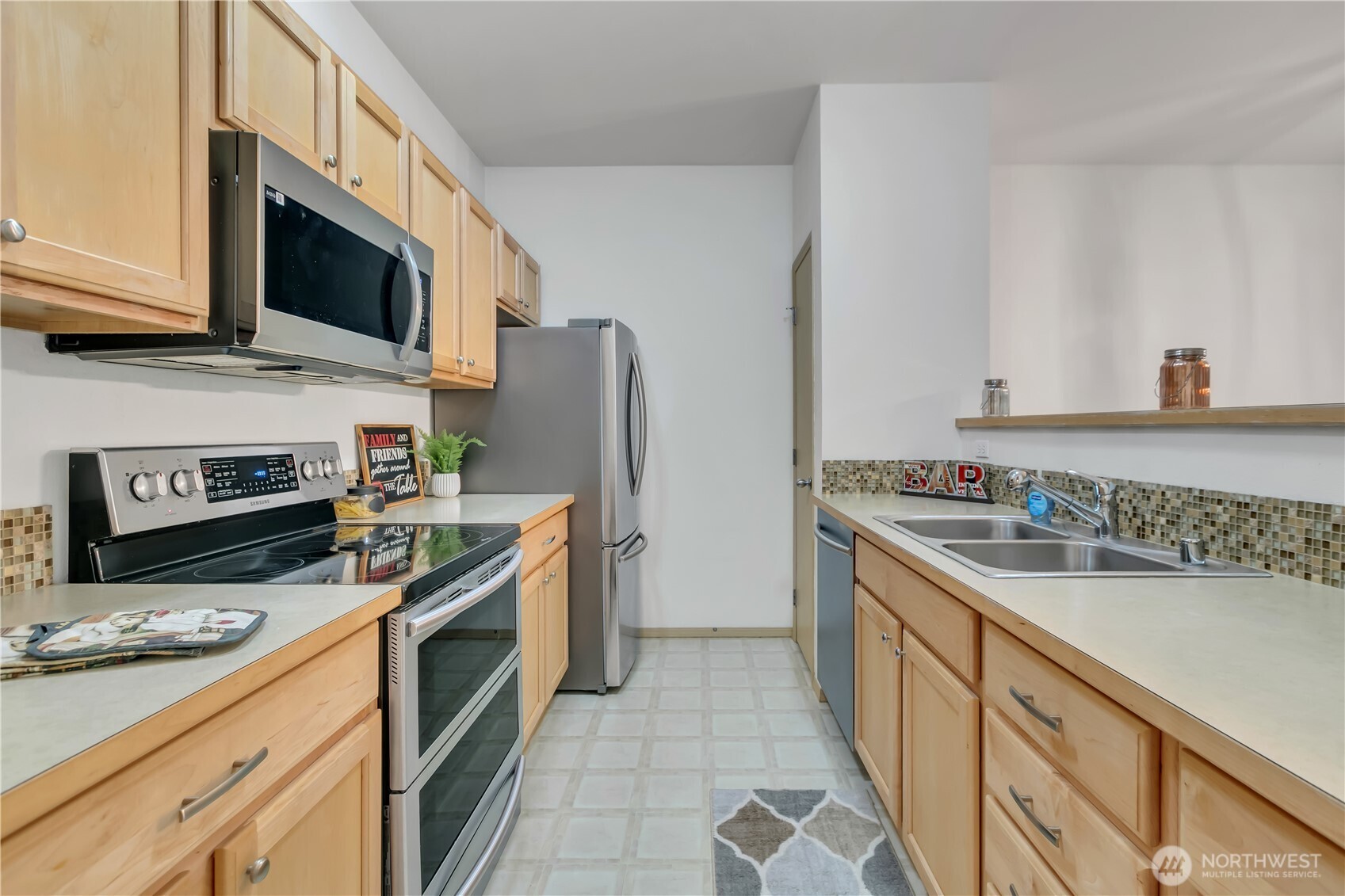 3012 Southeast 8th Place, Unit 1117 Renton, WA 98058 - Photo 11 of 28 a kitchen with stainless steel appliances granite countertop a stove a sink and a microwave