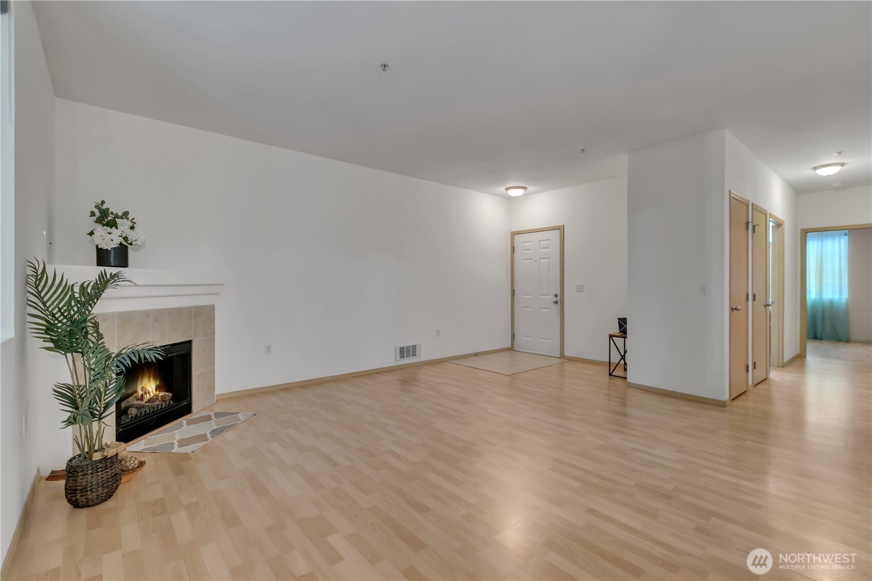 3012 Southeast 8th Place, Unit 1117 Renton, WA 98058 - Photo 6 of 28 a view of empty room with wooden floor and fireplace