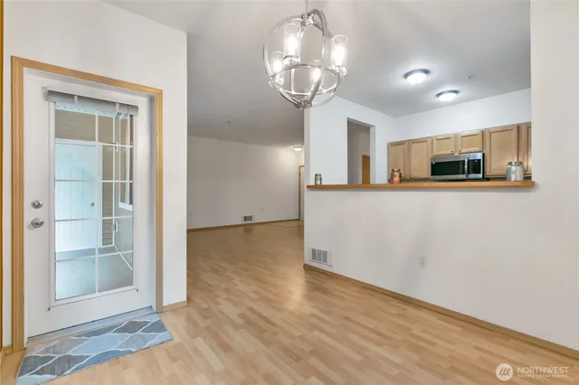 a view of a kitchen with wooden floor and chandelier
