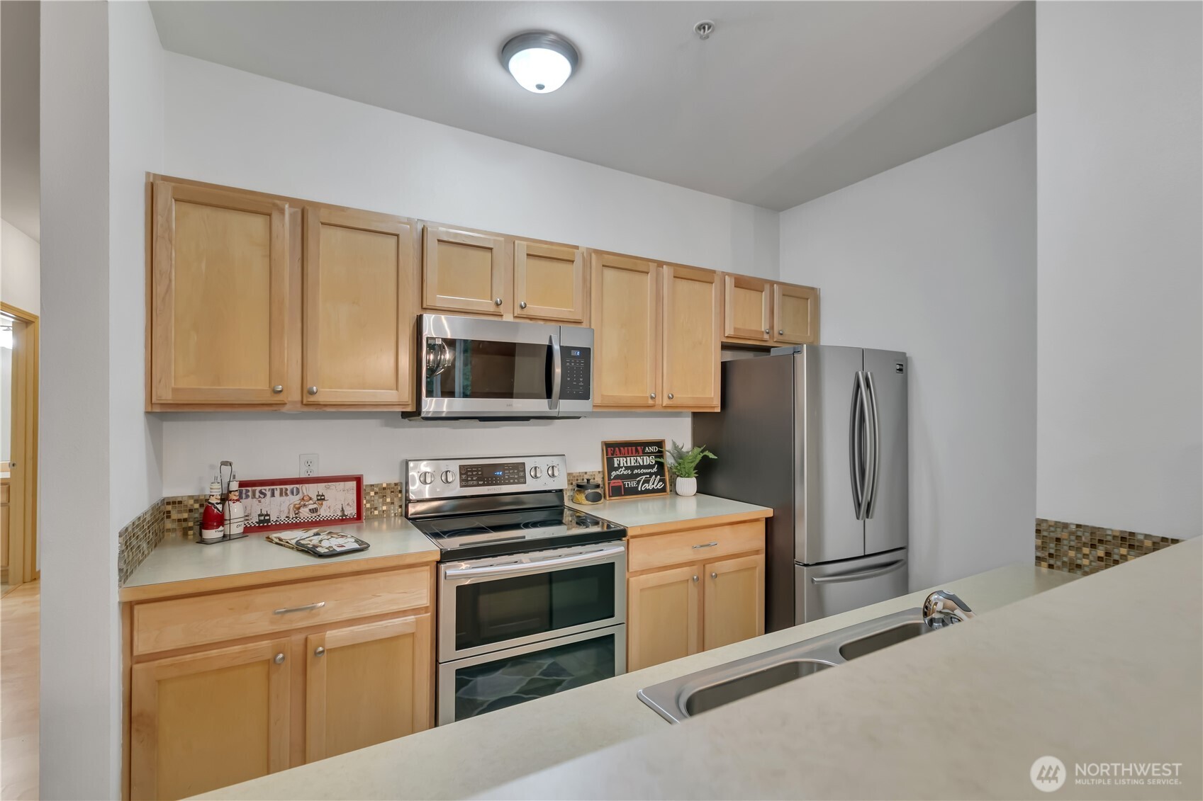 3012 Southeast 8th Place, Unit 1117 Renton, WA 98058 - Photo 9 of 28 a kitchen with stainless steel appliances granite countertop a refrigerator stove and sink