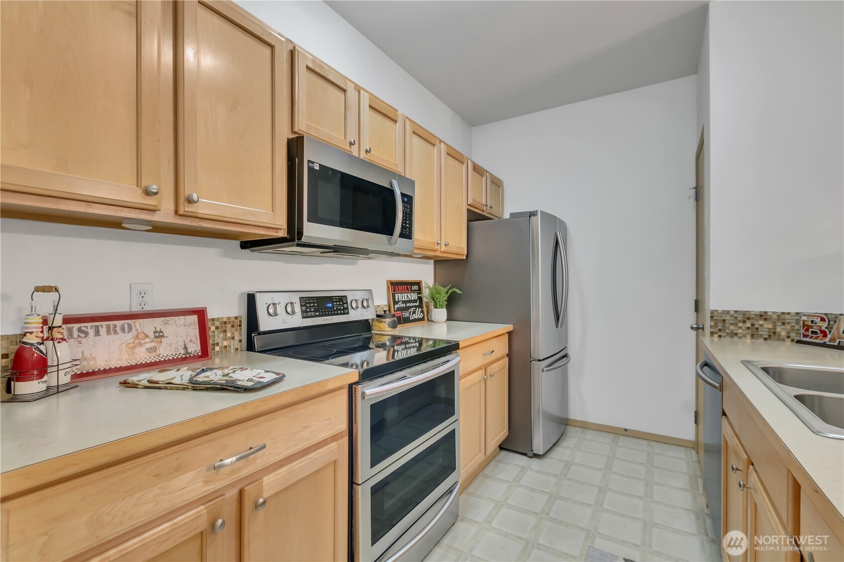 3012 Southeast 8th Place, Unit 1117 Renton, WA 98058 - Photo 10 of 28 a kitchen with stainless steel appliances granite countertop a refrigerator stove and sink