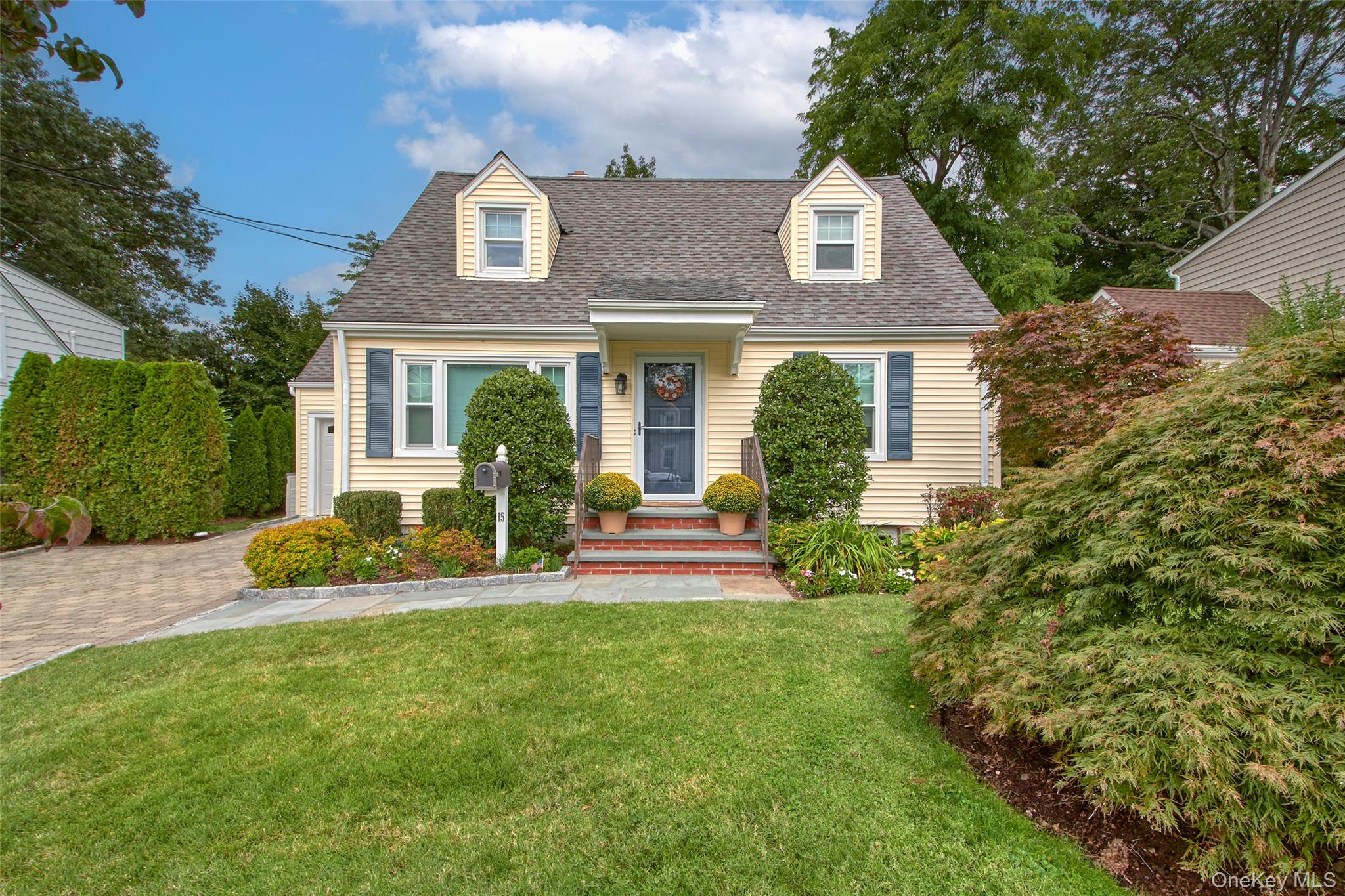 a front view of a house with a garden and plants