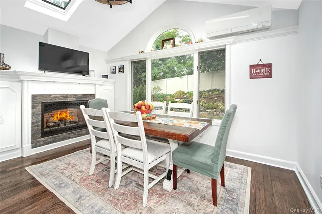 a dining room with furniture a fireplace and wooden floor