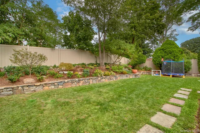 a patio with table and chairs and potted plants