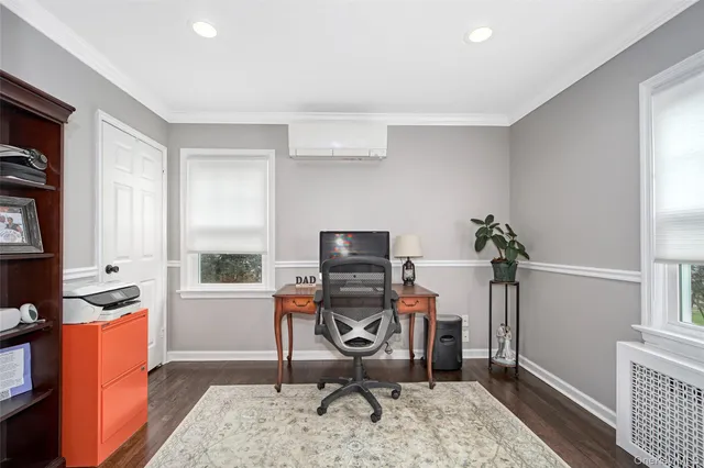 a view of a workspace with furniture and a window