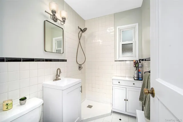 a bathroom with a sink a toilet and shower