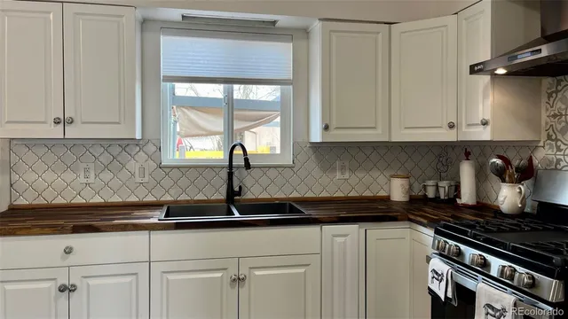 a kitchen with granite countertop a sink a stove and cabinets