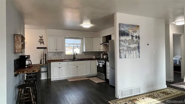 a kitchen with a refrigerator and a stove top oven