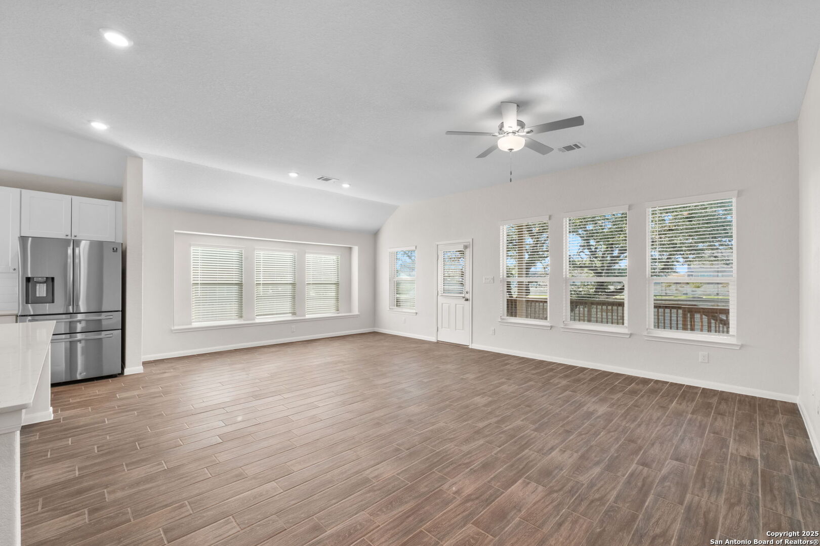 6056 Draw Loop Bulverde, TX 78163 - Photo 18 of 36 a view of an empty room with a kitchen and wooden floor