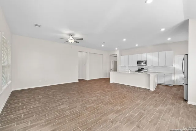 a view of kitchen with kitchen island white cabinets and stainless steel appliances
