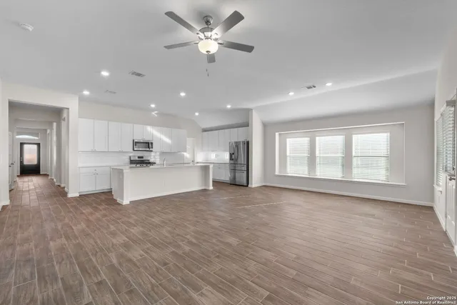 a view of empty room with wooden floor and window