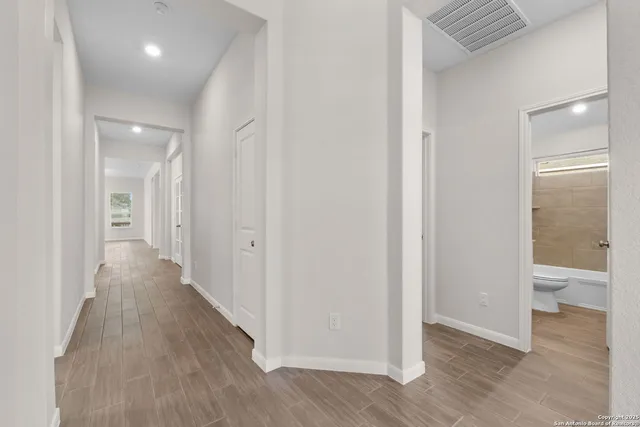 a view of a hallway with wooden floor