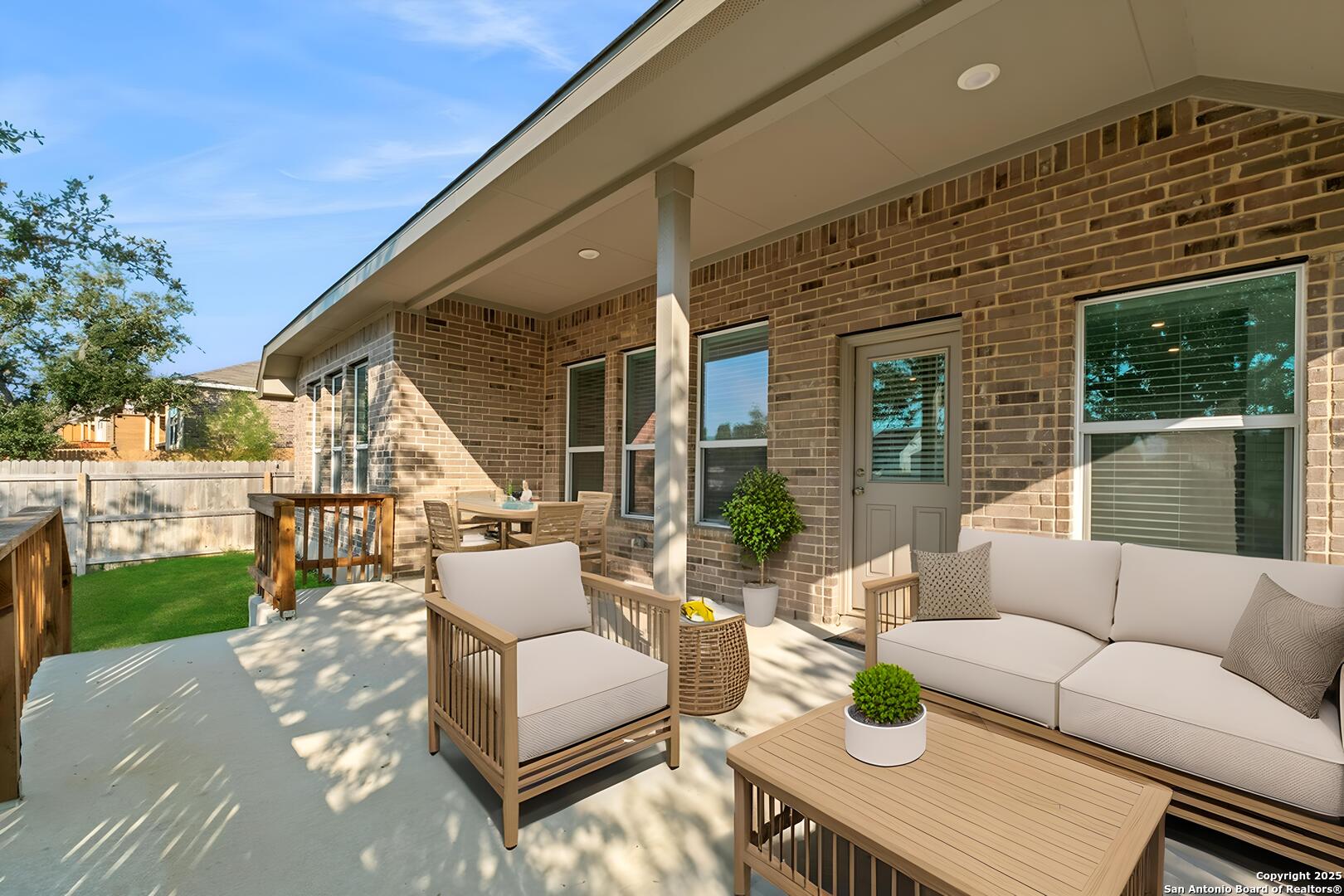 6056 Draw Loop Bulverde, TX 78163 - Photo 32 of 36 a view of a patio with couches table and chairs with wooden fence and plants