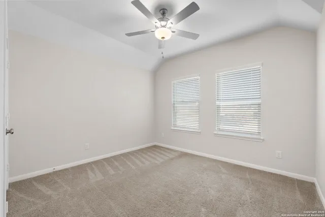 an empty room with a window and a fan