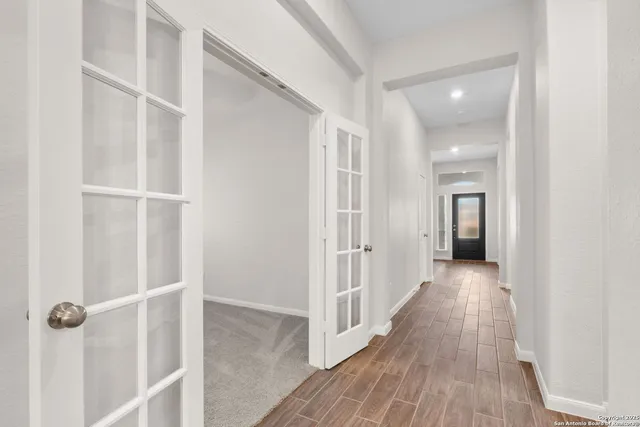 a view of a hallway with wooden floor and closet