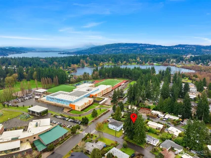 an aerial view of residential houses with outdoor space and lake view