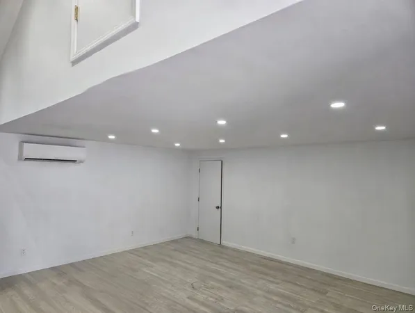 an empty room with wooden floor and entrance