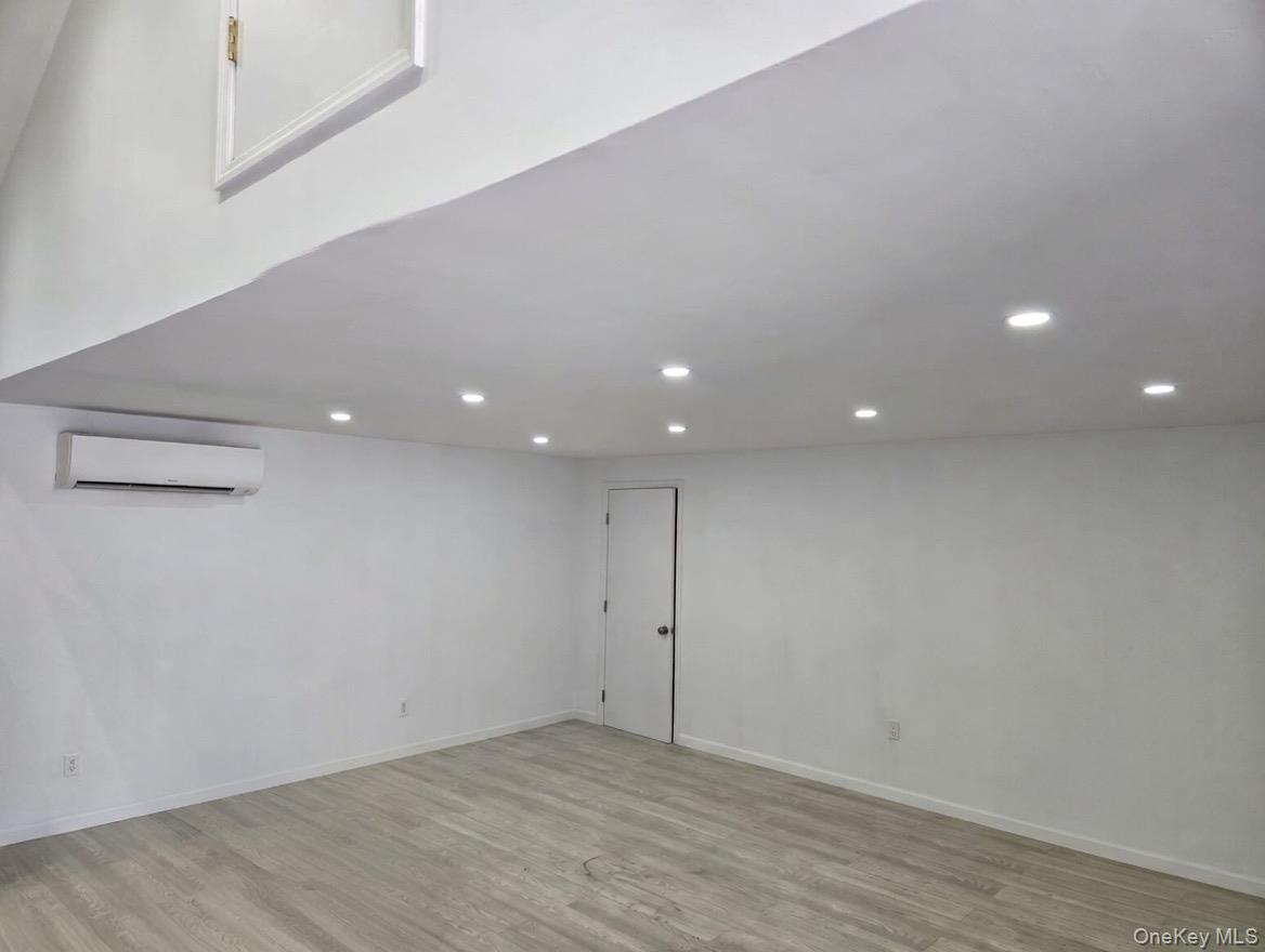 267 Morris Avenue Inwood, NY 11096 - Photo 5 of 10 an empty room with wooden floor and entrance