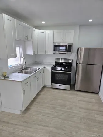 a kitchen with stainless steel appliances a stove a sink a refrigerator a microwave and cabinets