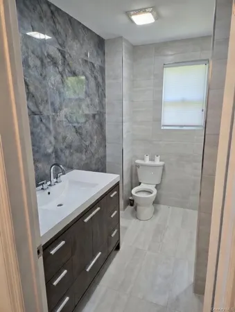 a bathroom with a toilet sink and a mirror