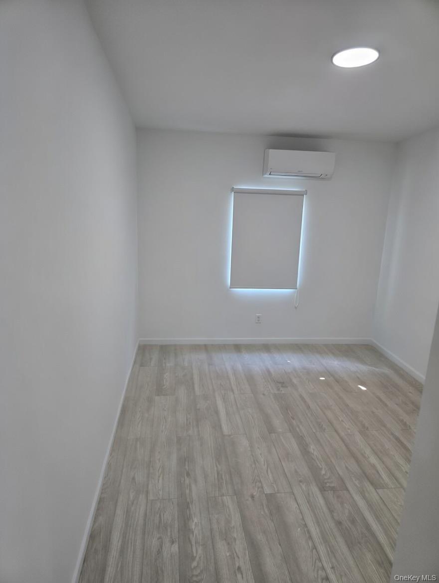 267 Morris Avenue Inwood, NY 11096 - Photo 9 of 10 an empty room with wooden floor and windows