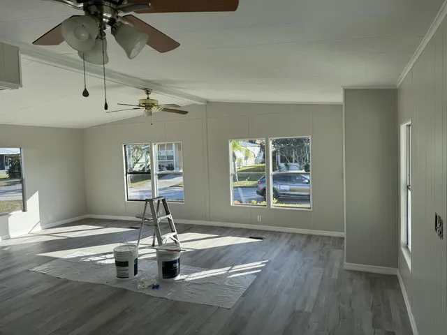 a dining room with wooden floor a chandelier and windows