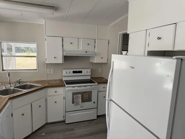 a kitchen with cabinets appliances a sink and a window