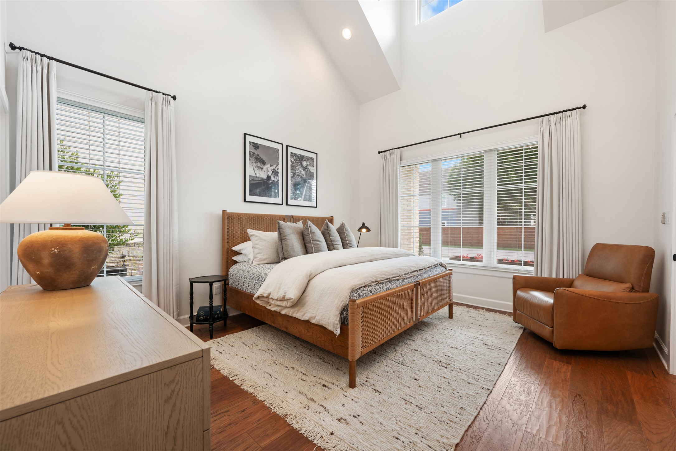 1301 West Street Georgetown, TX 78626 - Photo 19 of 40 Natural light floods this serene bedroom, highlighting the rich hardwood floors and vaulted ceilings.