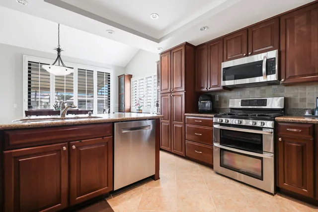 a kitchen with stainless steel appliances granite countertop a stove microwave and refrigerator