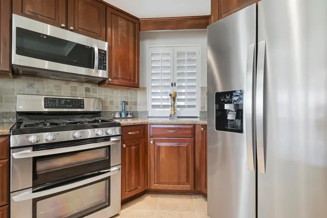 a kitchen with kitchen island granite countertop a sink window and cabinets