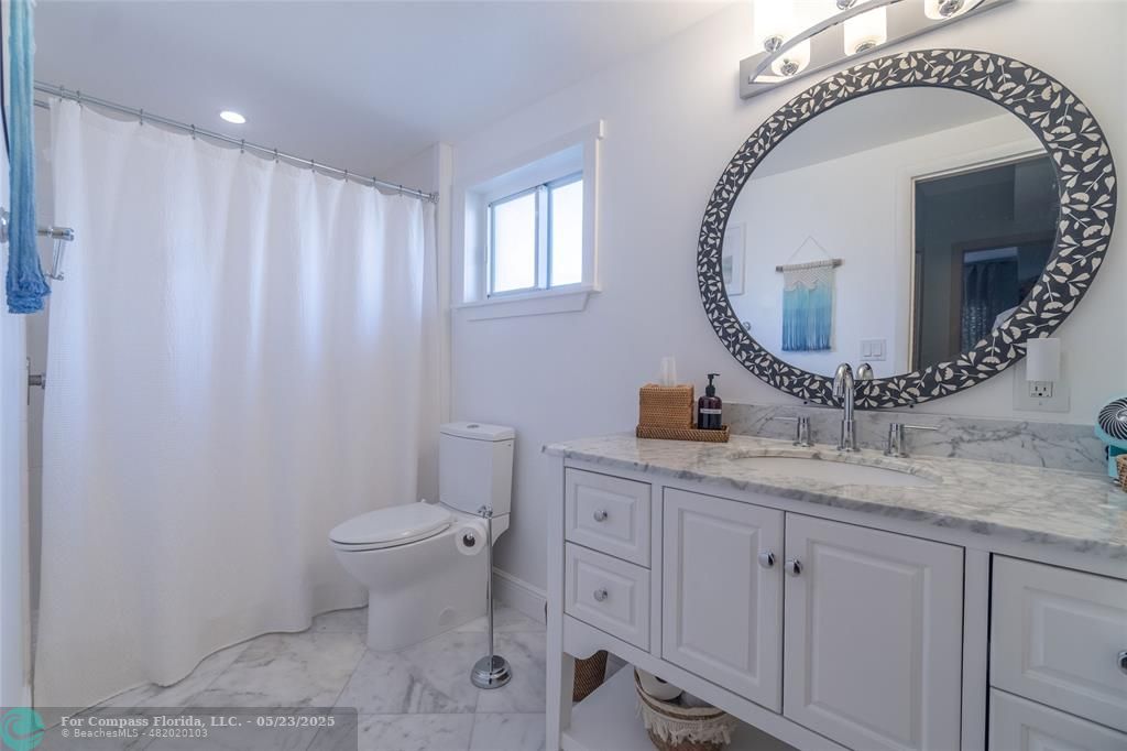 6520 North Ocean Boulevard, Unit 22 Boynton Beach, FL 33435 - Photo 12 of 27 a bathroom with a toilet a sink and mirror
