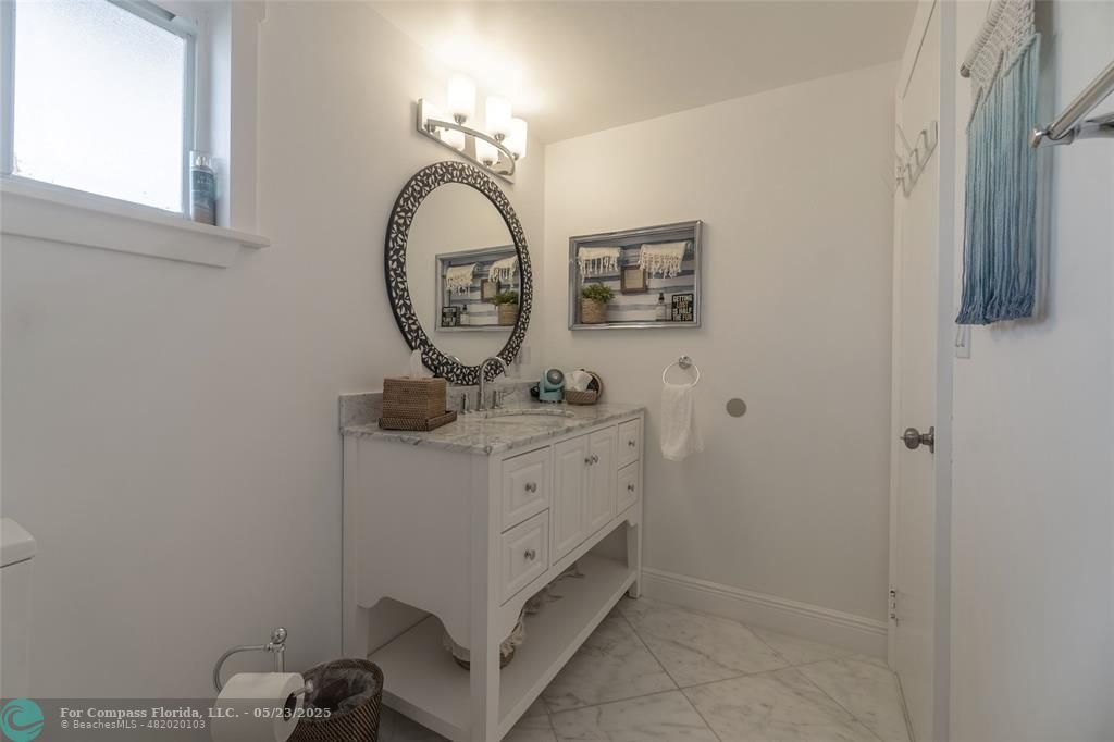 6520 North Ocean Boulevard, Unit 22 Boynton Beach, FL 33435 - Photo 13 of 27 a bathroom with a sink a mirror and vanity