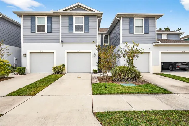 a front view of a house with a garden and plants
