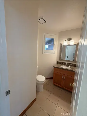 a bathroom with a granite countertop toilet and a sink