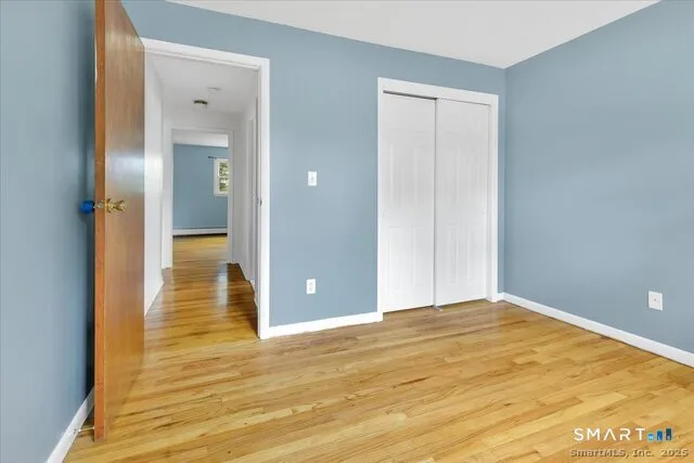 a view of an empty room with wooden floor