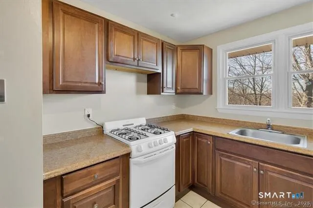 a kitchen with stainless steel appliances granite countertop a sink stove and cabinets