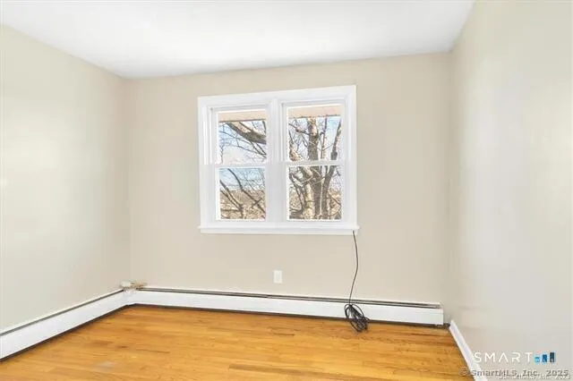 a view of a room with wooden floor and window
