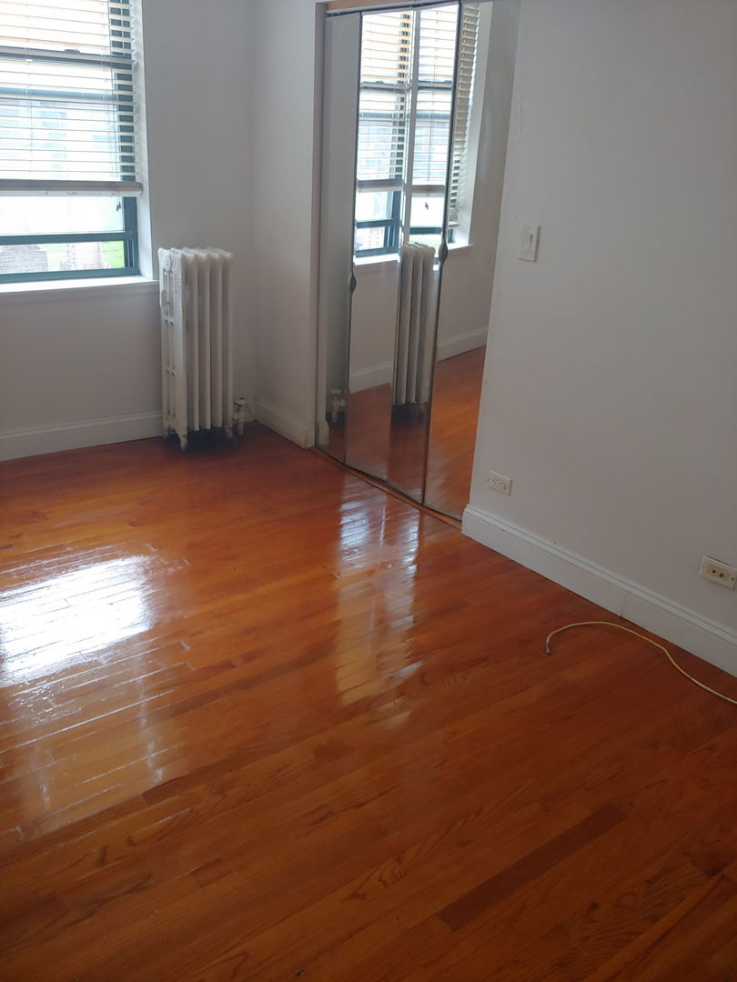 307 East 50th Street, Unit 307A Chicago, IL 60615 - Photo 10 of 10 an empty room with wooden floor and windows