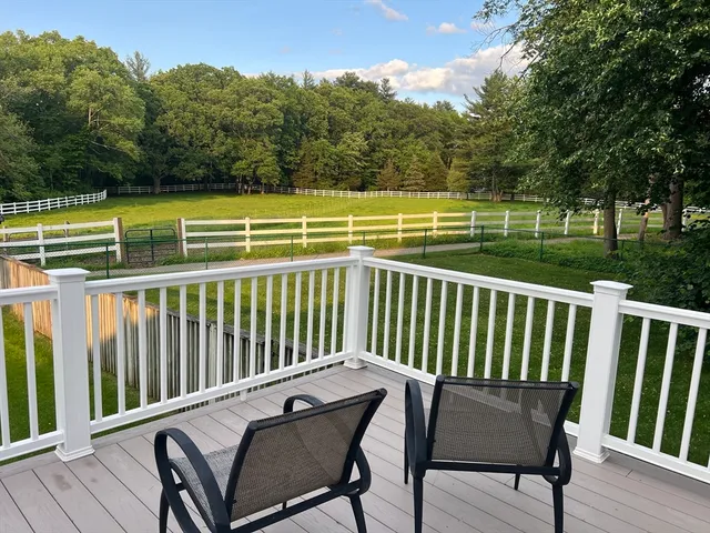 a balcony with wooden floor table and chairs