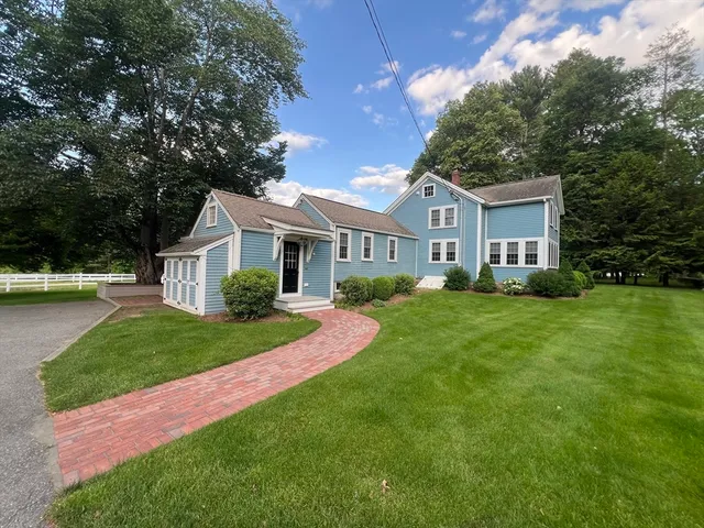 a front view of a house with a yard and trees