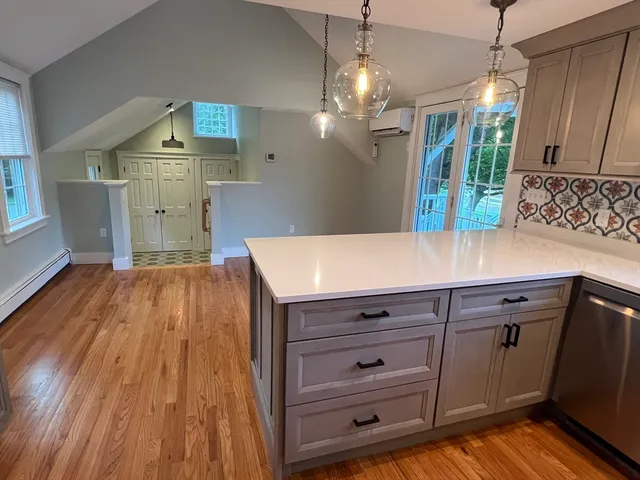 a view of kitchen center island wooden floor and cabinets
