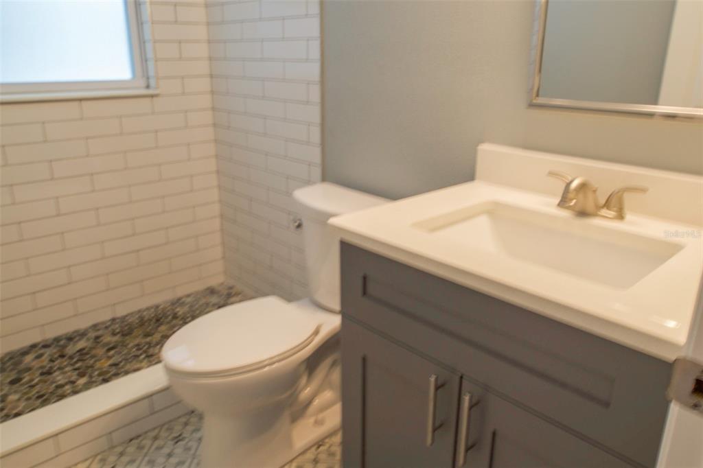 715 Bay Street Dunedin, FL 34698 - Photo 16 of 19 a bathroom with a sink a toilet and a mirror