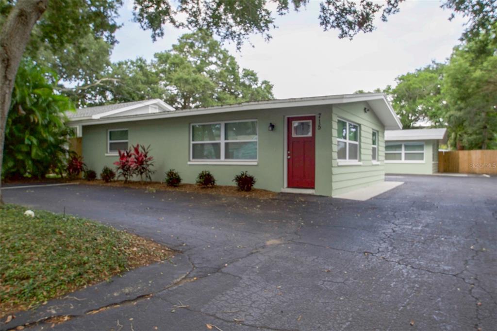 715 Bay Street Dunedin, FL 34698 - Photo 2 of 19 a view of a house with potted plants and a large tree