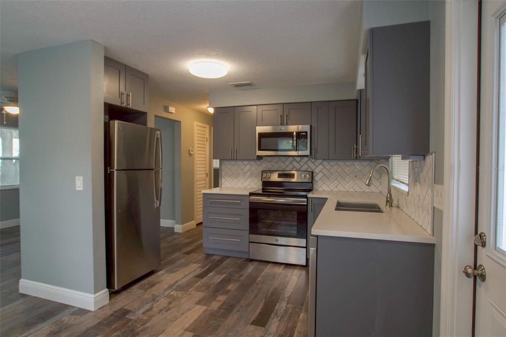 715 Bay Street Dunedin, FL 34698 - Photo 3 of 19 a kitchen with kitchen island a refrigerator stove and sink