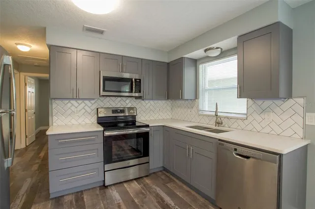 a kitchen with a sink stove and microwave