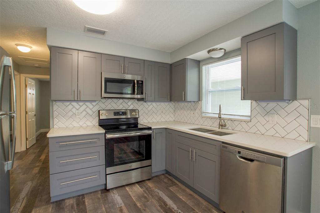 715 Bay Street Dunedin, FL 34698 - Photo 4 of 19 a kitchen with a sink stove and microwave