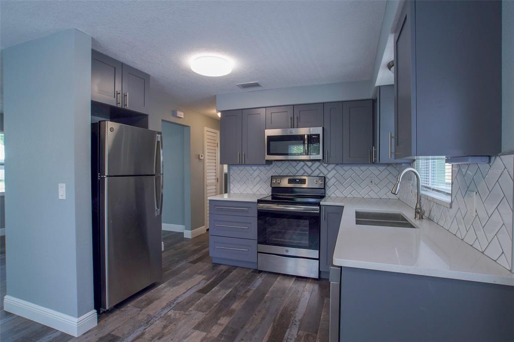 715 Bay Street Dunedin, FL 34698 - Photo 6 of 19 a kitchen with stainless steel appliances a refrigerator sink and microwave