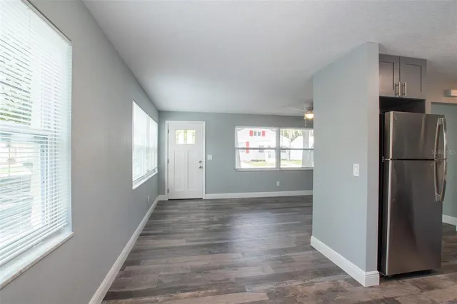 a view of an empty room with window and wooden floor